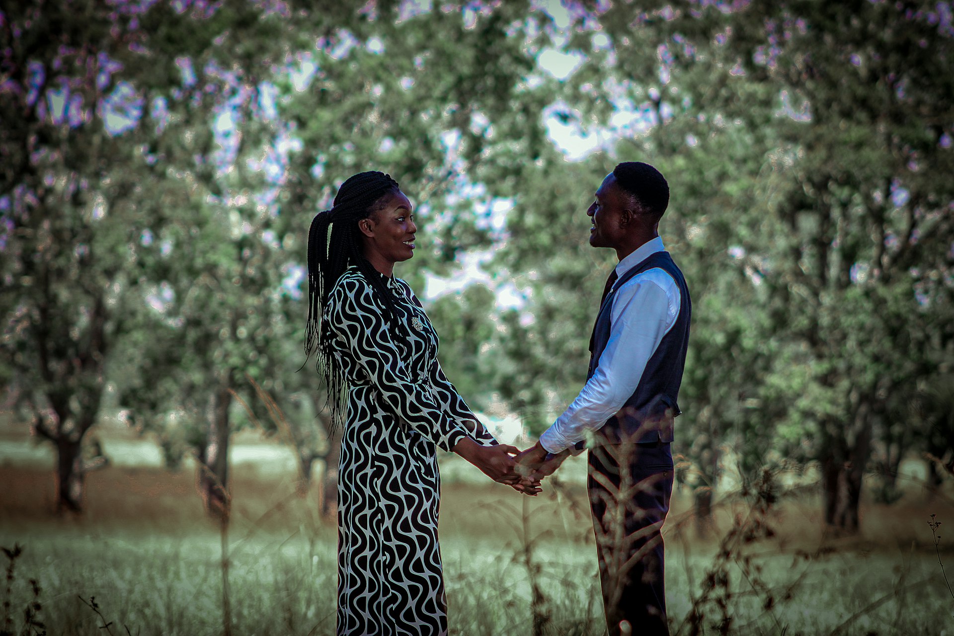 A man and a woman holding hands in a field